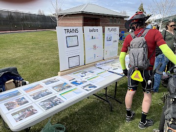 AAWA table at Yakima Earth Day, with guy in bike gear viewing the materials.